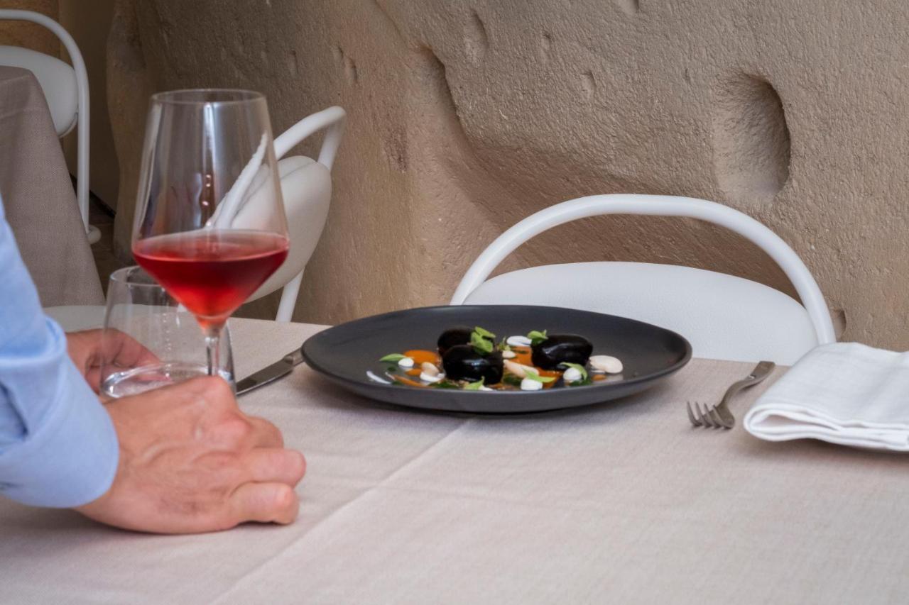 Aquatio Cave Luxury Hotel & Spa Matera Exterior photo A glass of wine and a plate of food
